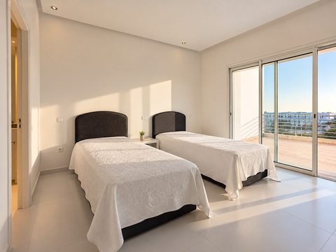 Twin bedroom opening onto a terrace at the Imi Ouaddar villa